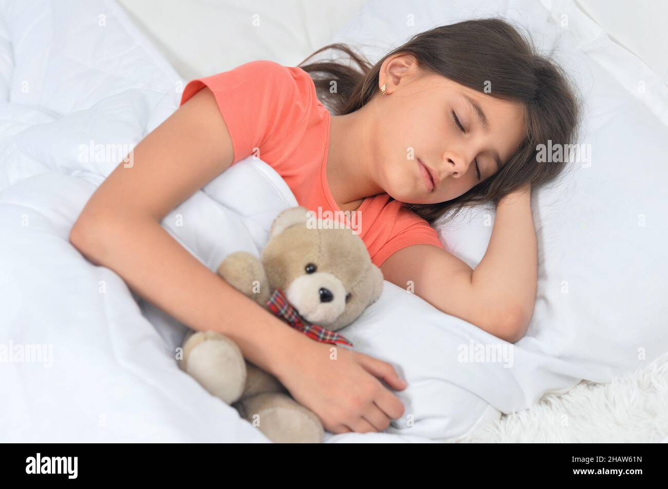 Cute little girl sleeping in bed with teddy bear Stock Photo - Alamy