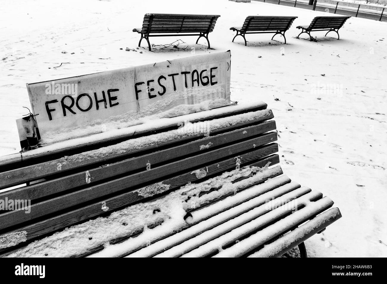 Desolate, snowy wooden bench with Christmas motto, Berlin, Germany Stock Photo