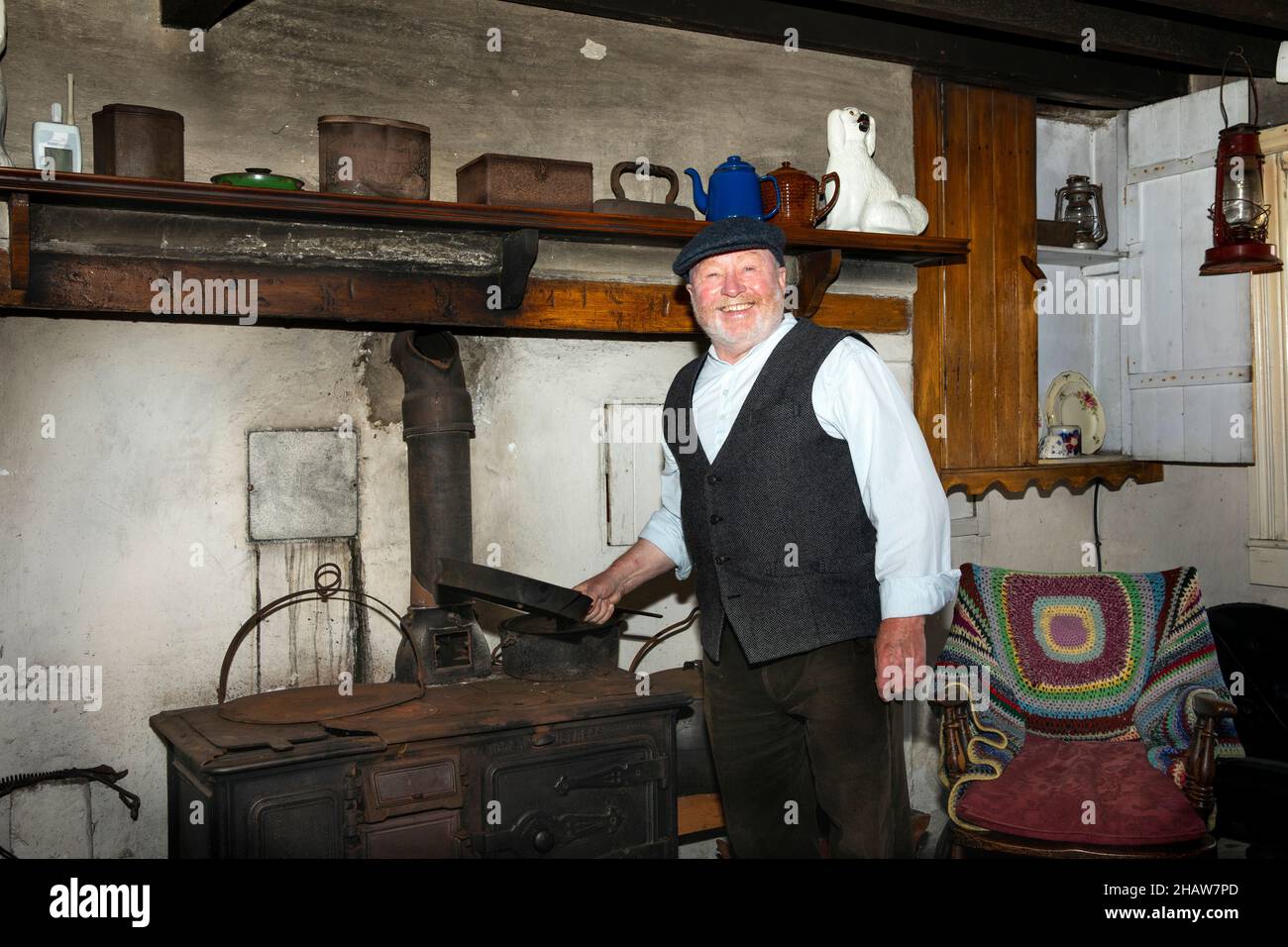 UK Northern Ireland, Co Down, Holywood, Ulster Folk Museum, costumed staff member inside Drumnahunshn Farm Stock Photo