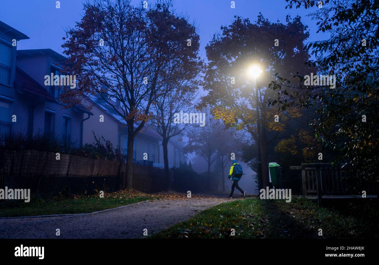 Schoolchild in foggy weather on the way to school in Markt Swabia, Bavaria, Germany Stock Photo