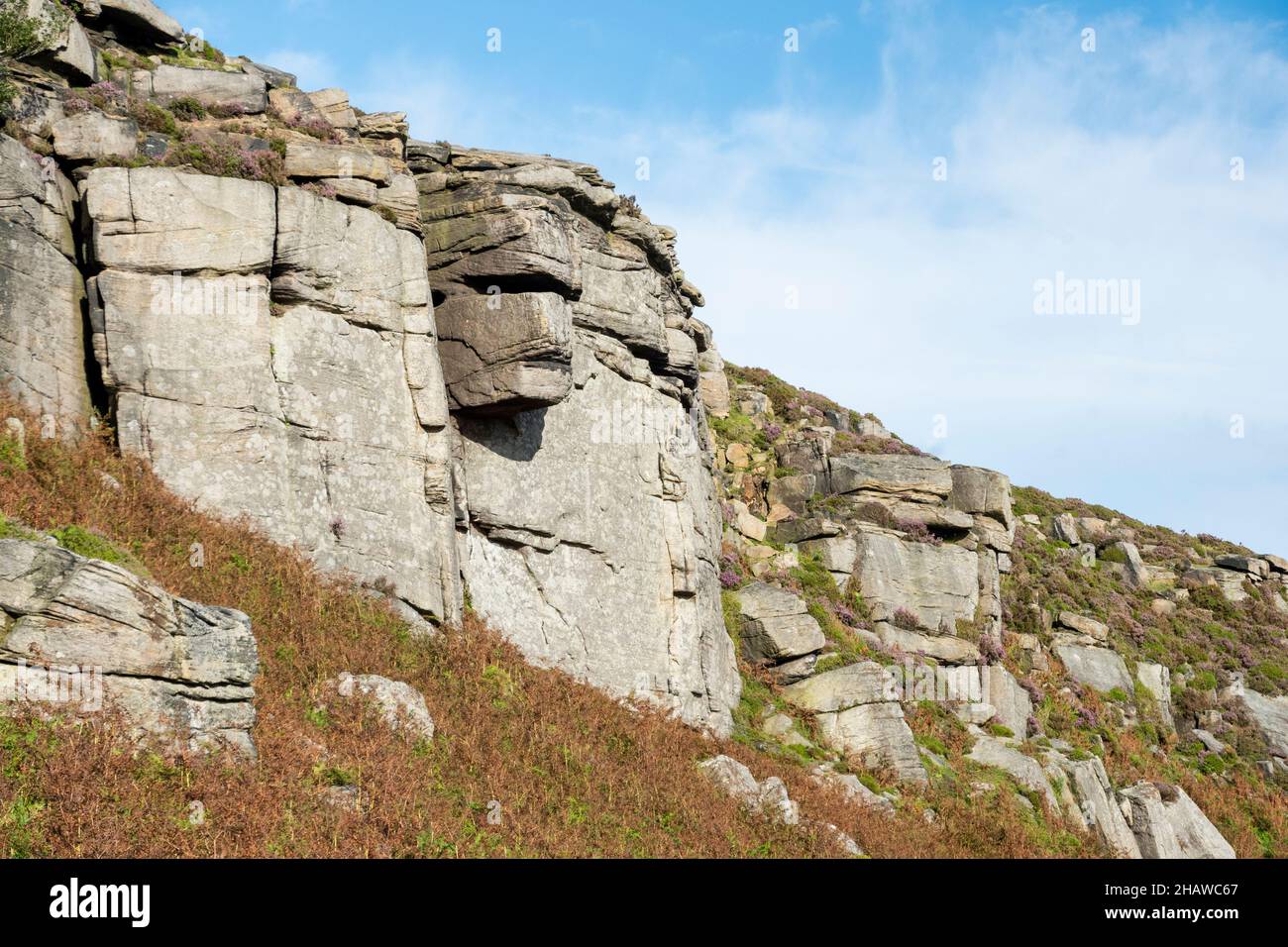 A stern face looks down from the cliff face of Stanage Edge, a 4 mile long gritstone escarpment in the Peak District, Derbyshire, UK Stock Photo