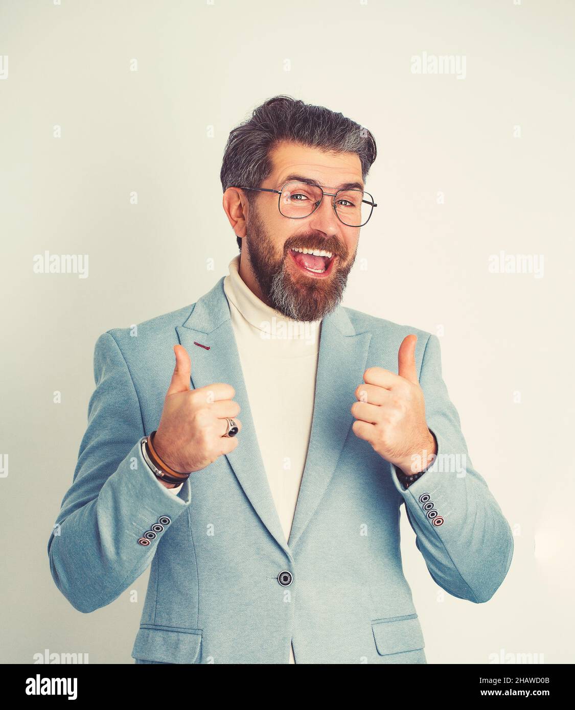 Positive and confident young business man showing thumbs up, isolated on white background. Stock Photo