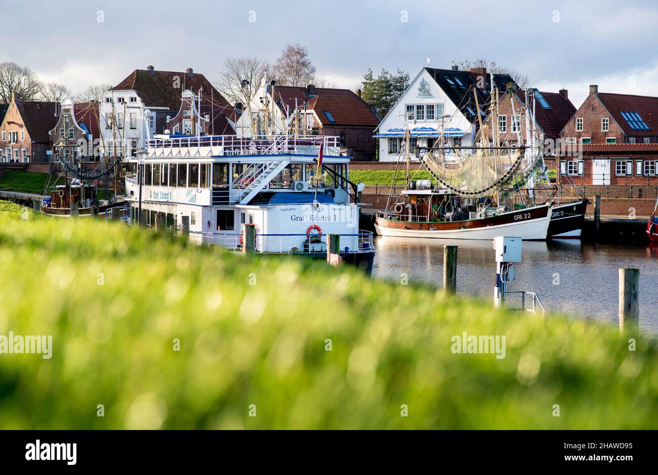 15 December 2021, Lower Saxony, Greetsiel: The excursion ship 'Graf Edzard I' and several shrimp cutters are moored in the harbour of the village in sunny weather. Photo: Hauke-Christian Dittrich/dpa Stock Photo
