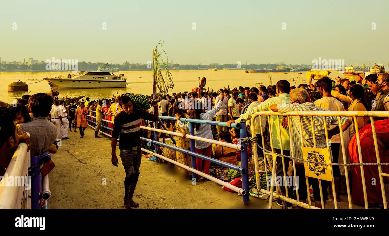 Mass of Devotees,on bank of river Ganga,for seeing, Chhat God ,setting Sun,as start of Chhat ritual, Kolkata,India. Stock Photo
