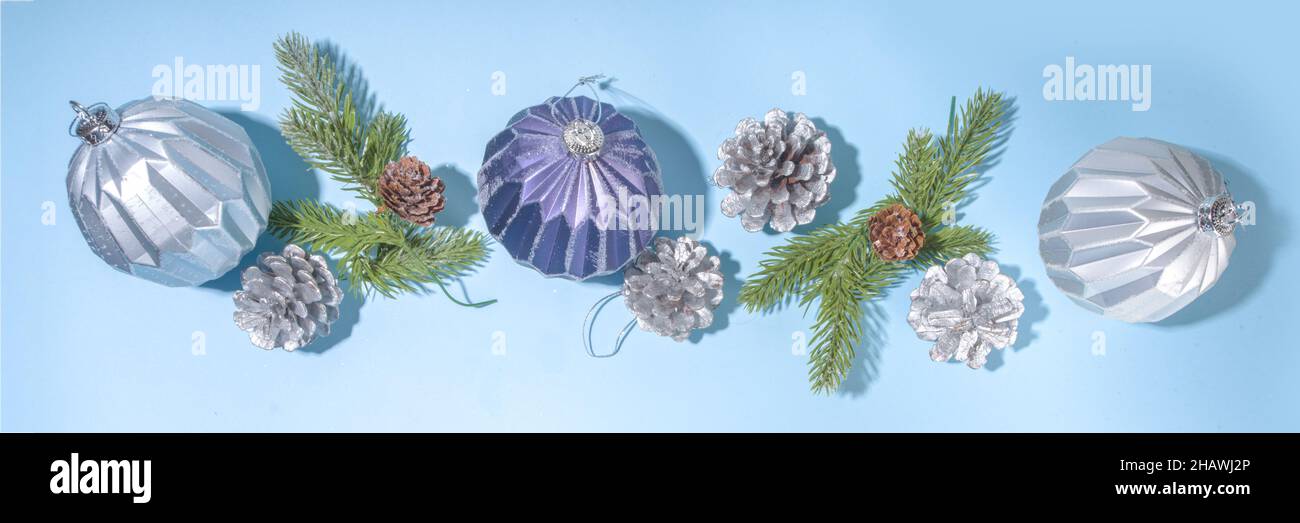 Christmas New Year background. Greeting card, invitation mockup with blue and silver Xmas tree balls, christmas-tree cones on light blue background, f Stock Photo