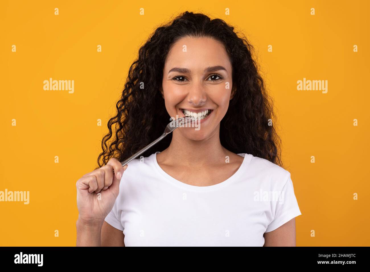 Portrait of Smiling Latin Lady Holding Fork In Mouth Stock Photo Alamy