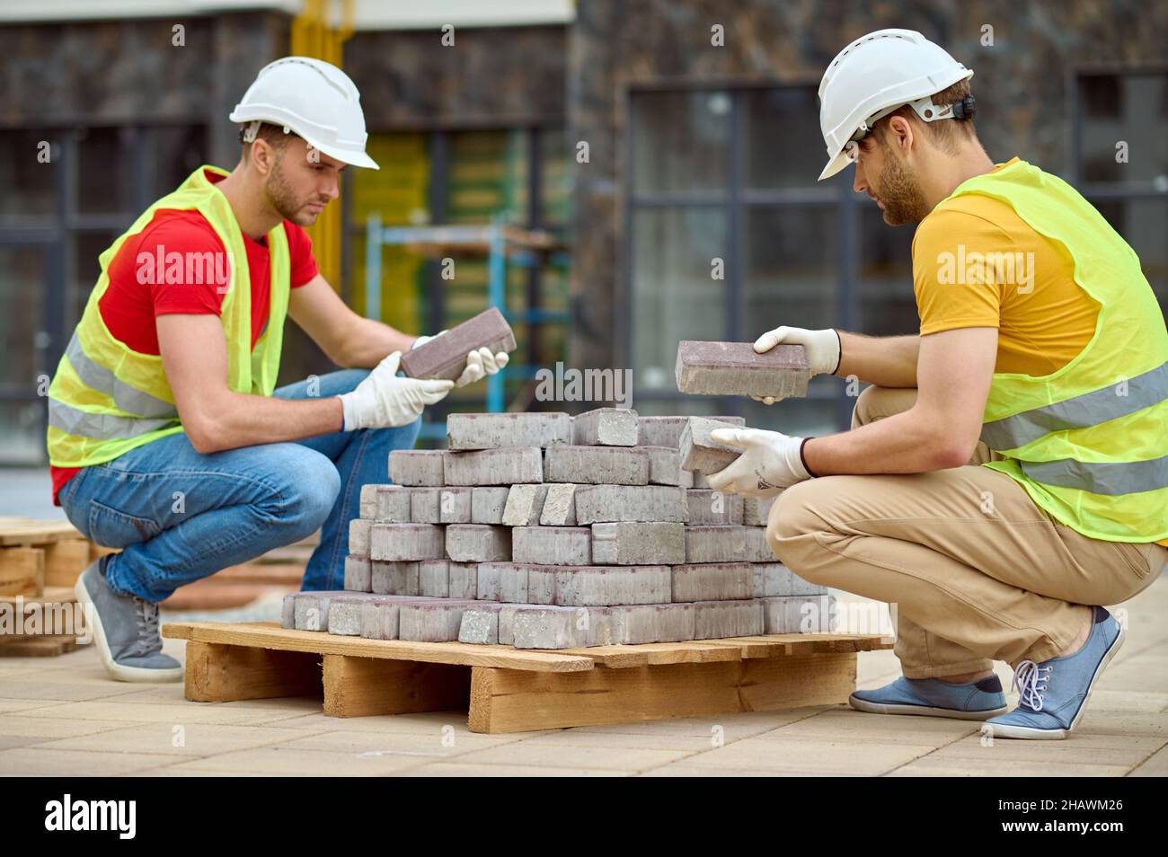 Two men stacking bricks at construction site Stock Photo Alamy