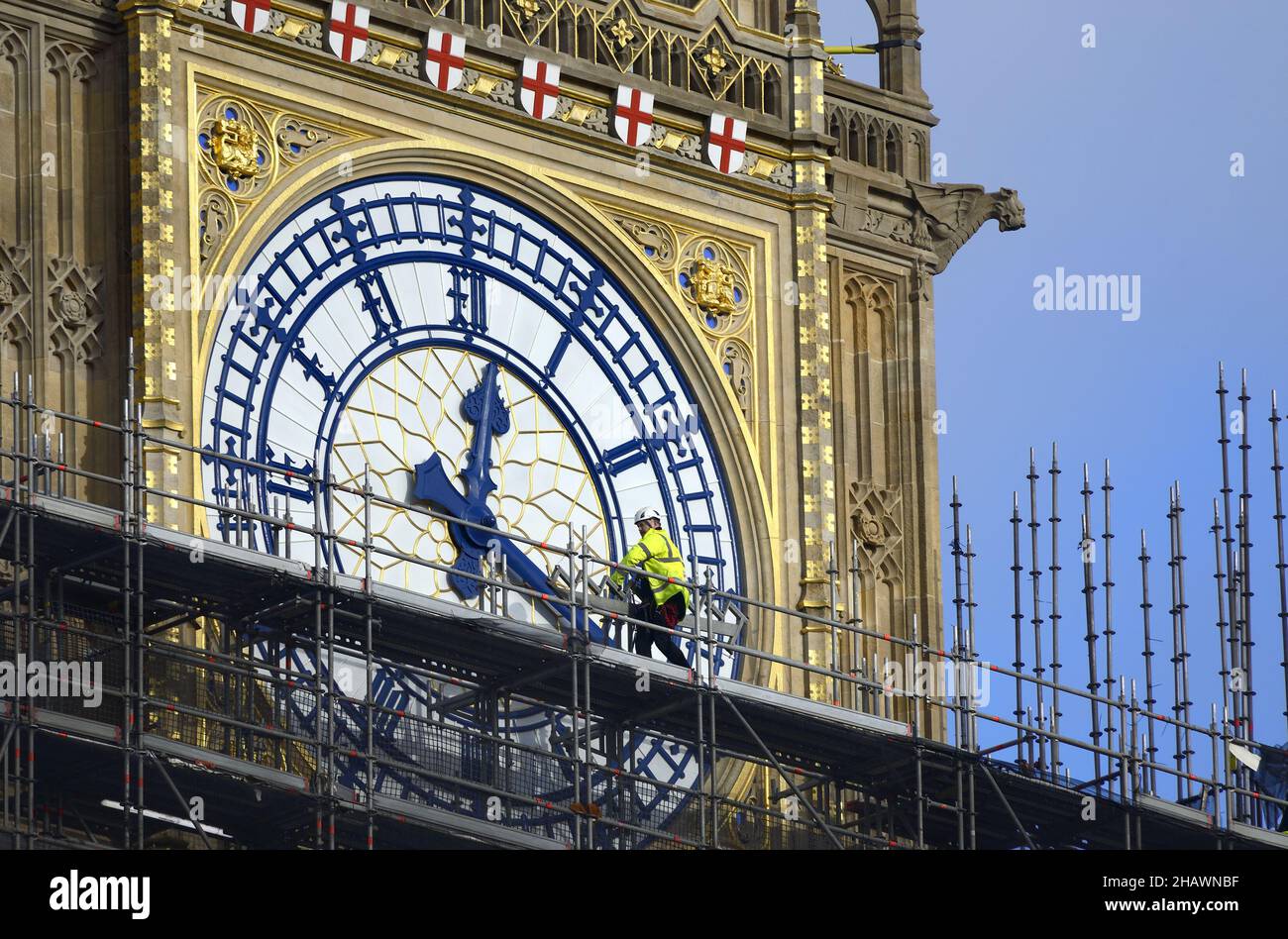 London, England, UK. Workman in hi-vis walking past the clockface of Big Ben as the scaffolding is removed following renovations and cleaning, Decembe Stock Photo