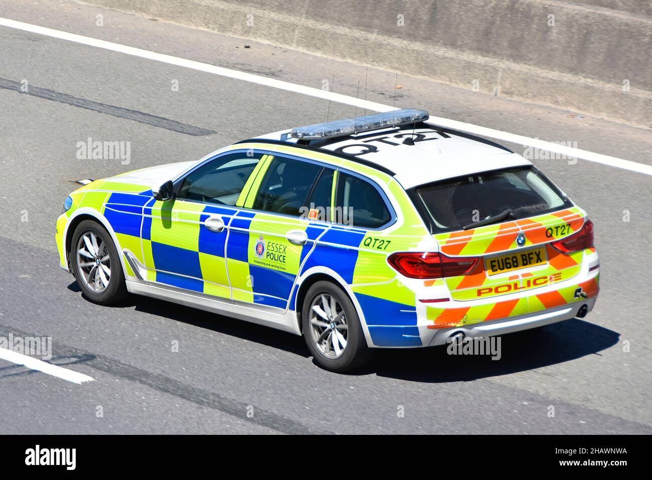 Close up aerial side and back view of Essex Police patrol car driving along English motorway with reflective high visibility battenberg  markings UK Stock Photo
