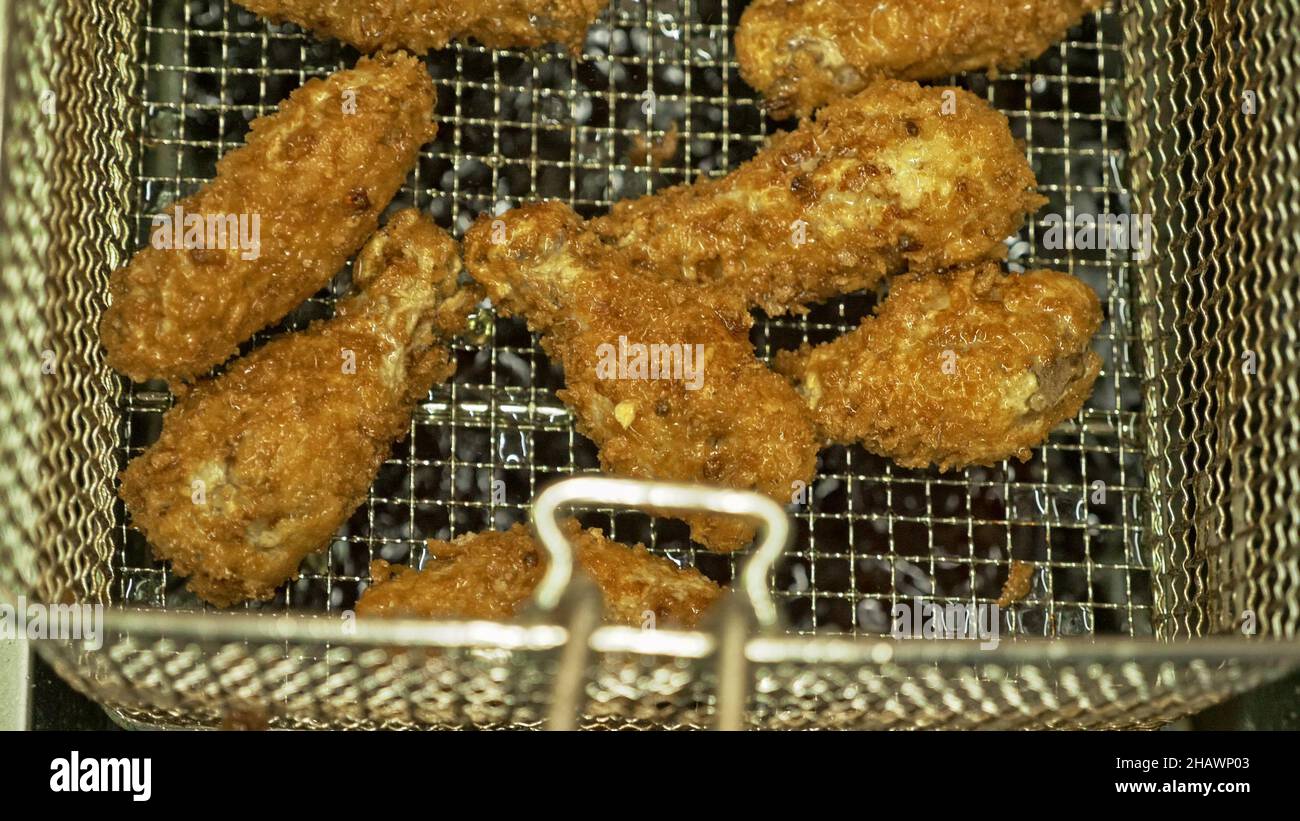 Deep fryer with boiling oil and chicken. Large, deep fryer container