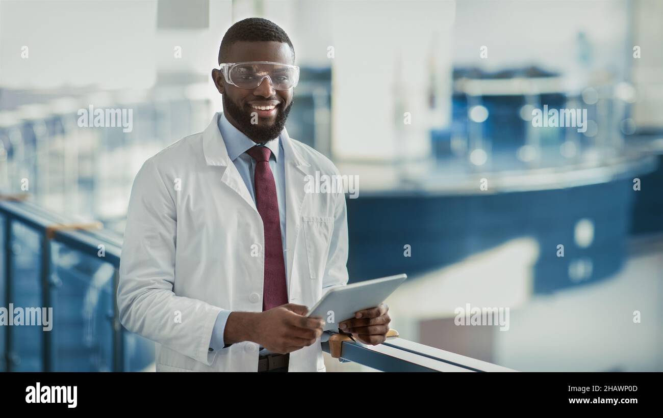 Happy young black medical scientist using digital tablet Stock Photo