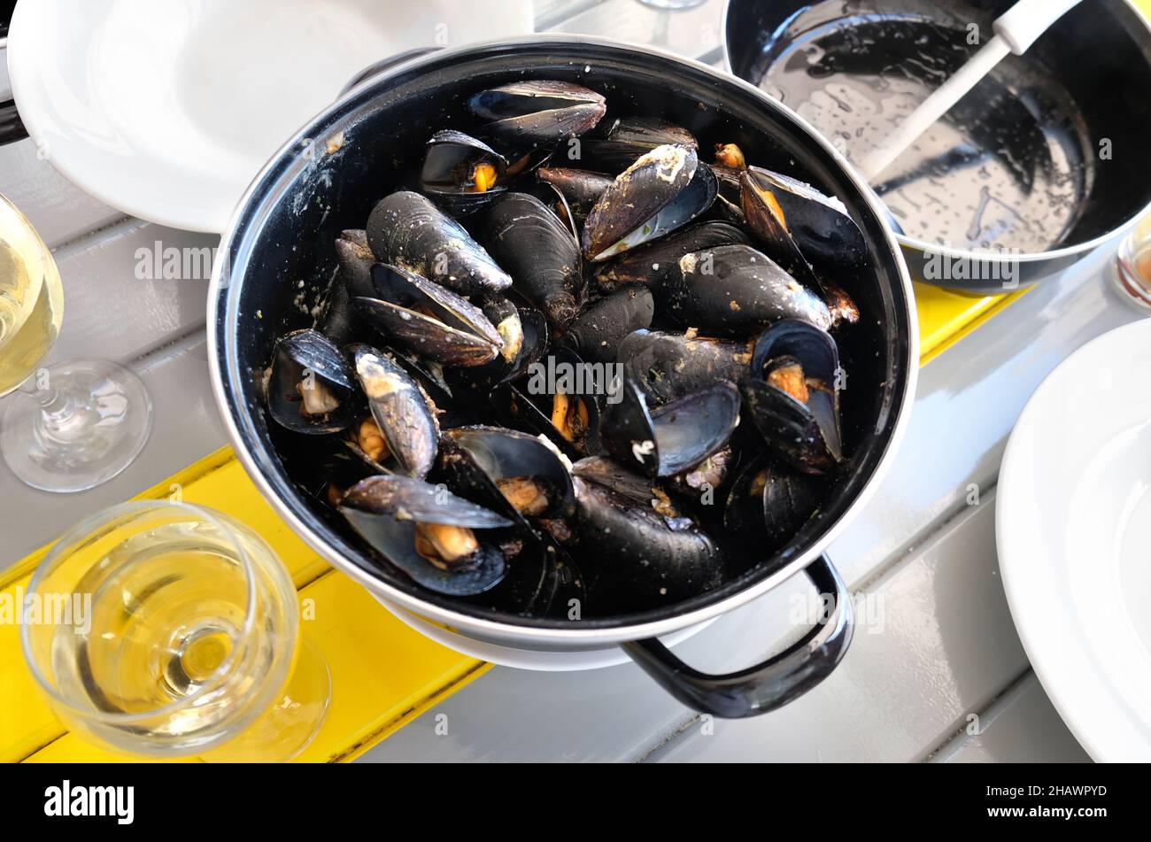 mussels stewed with wine on a served table Stock Photo