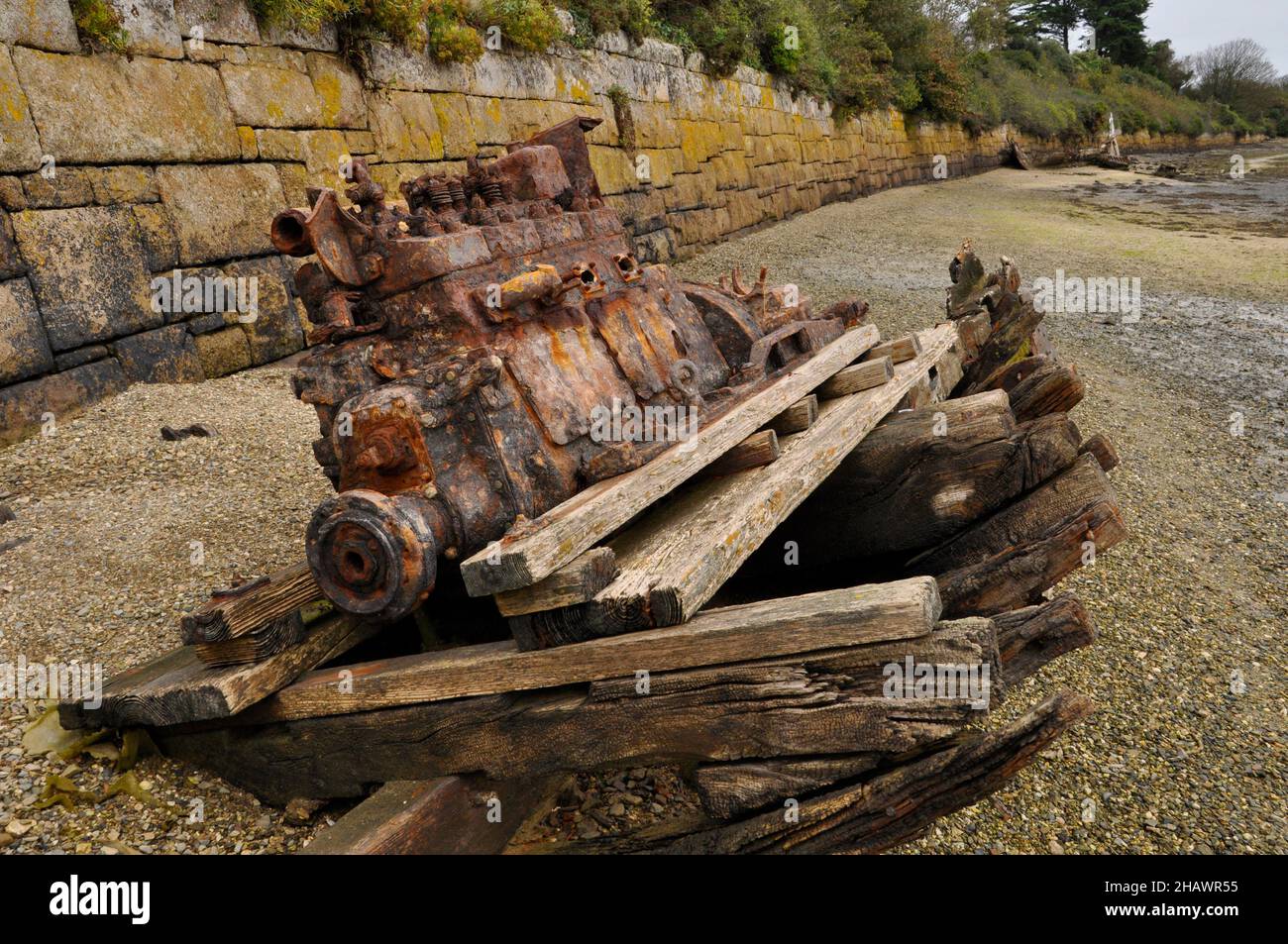 Remains of the engine and keel of a wrecked wooden boat on the foreshore in the tidal estuary of the river Hayle nr St.Ives in Cornwall, UK Stock Photo