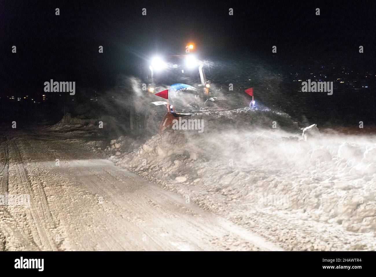 Snow removal vehicle equipped with snowplow on a winter evening in