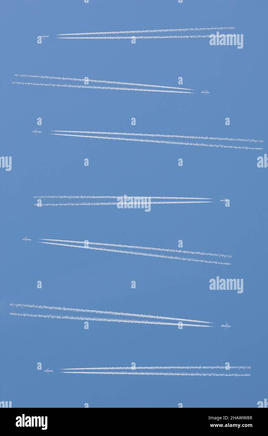Aircrafts with two engines crossing over blue cloudy sky. Congested airspace concept Stock Photo