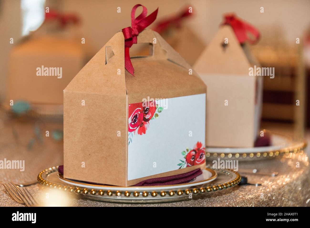 Brown carton souvenir boxes with red bows and blank white labels Stock