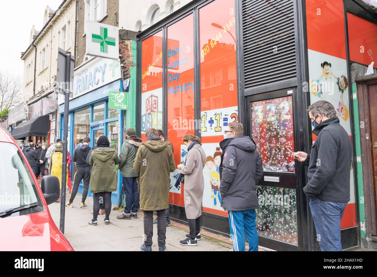 Local resident in Lewisham queue outside a pharmacy for the covid-19 booster jab, vaccination centre London England UK Stock Photo