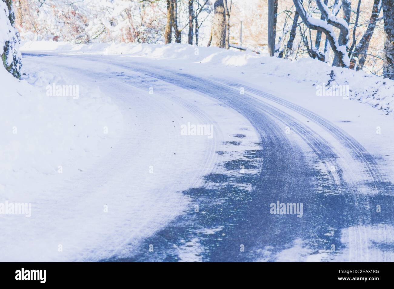 High angle view of an empty road with a tricky left turn covered with snow. Concept of road trip, extreme driving, safety on the roads, and environmen Stock Photo