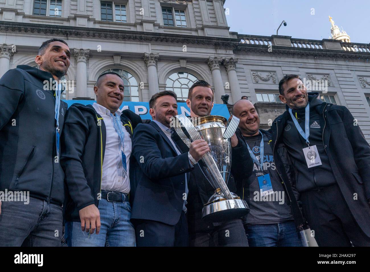 Coaching team with MLS Cup poses during celebration for NYCFC winning the 2021 MLS Cup on City Hall steps. NYCFC finished the regular season in 4th place and played almost all playoff games away. Winning the MLS Cup is the first trophy won by the franchise since it was established 7 years ago. NYCFC is part of the City Football Group which owns football clubs around the world. Sean Johnson was named MVP of the playofffs. Head coach Ronny Deila stands 3rd from right. (Photo by Lev Radin/Pacific Press) Stock Photo