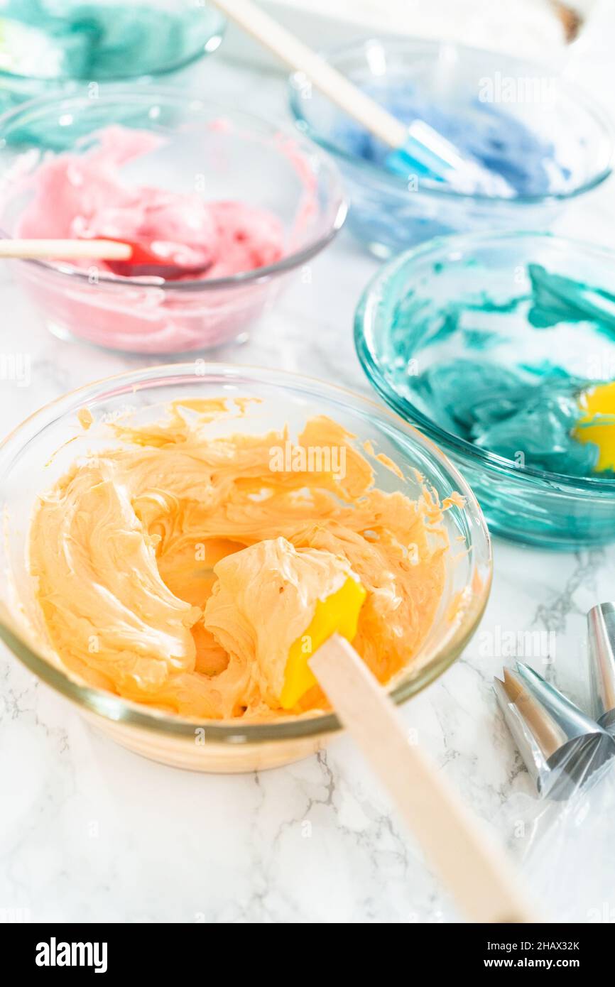 Mixing food coloring with Italian buttercream frosting Stock Photo Alamy