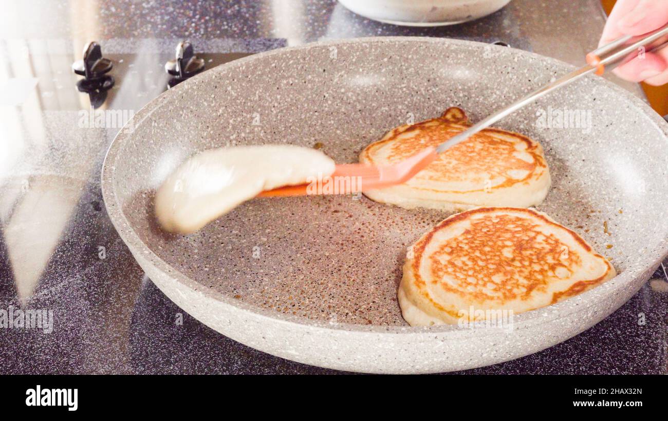 Frying pancakes in a frying pan over the electric stove Stock Photo - Alamy