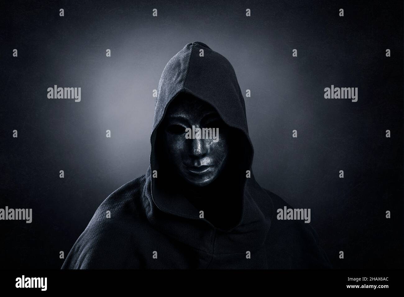 Scary figure with hooded cloak in the dark Stock Photo - Alamy