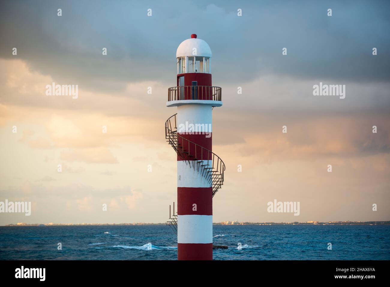 Amzing red and white lighthouse with spiral staircase on island in mexico at sunset Stock Photo