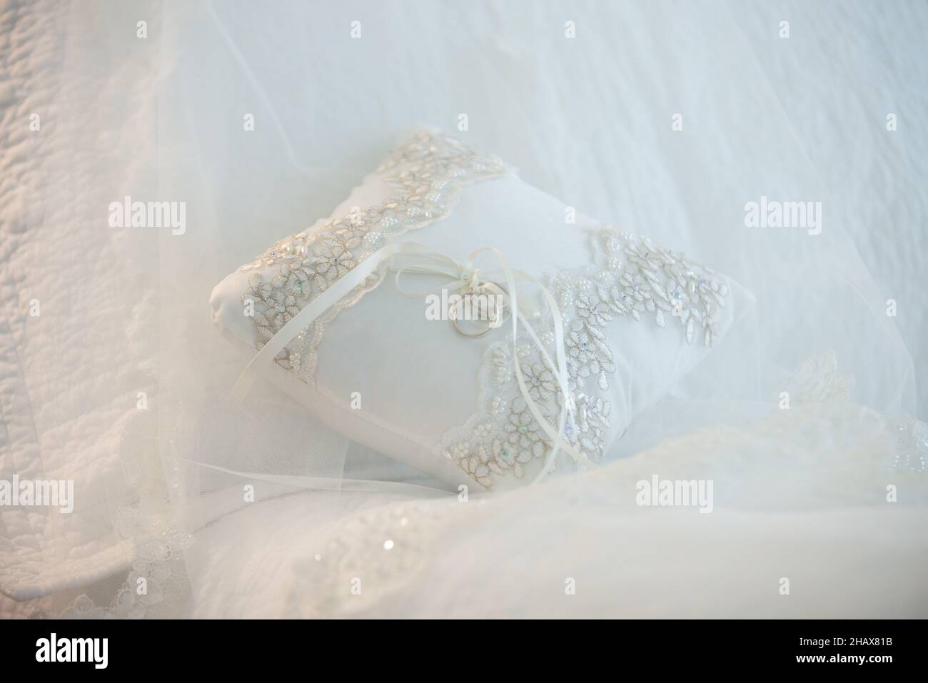 Wedding rings tied to ring bearers pillow on white background Stock