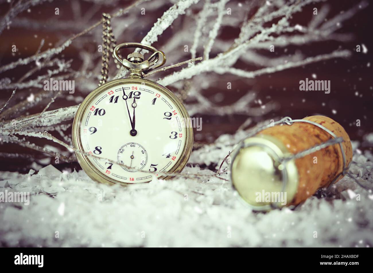 New Year midnight clock and champagne cork on snowy background Stock Photo