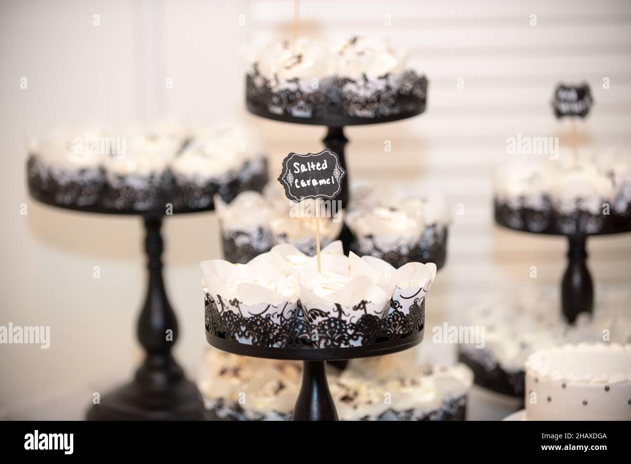 Black ast iron ornate cupcake towers with vanilla cupcakes that have chocolate fuge drizzle Stock Photo