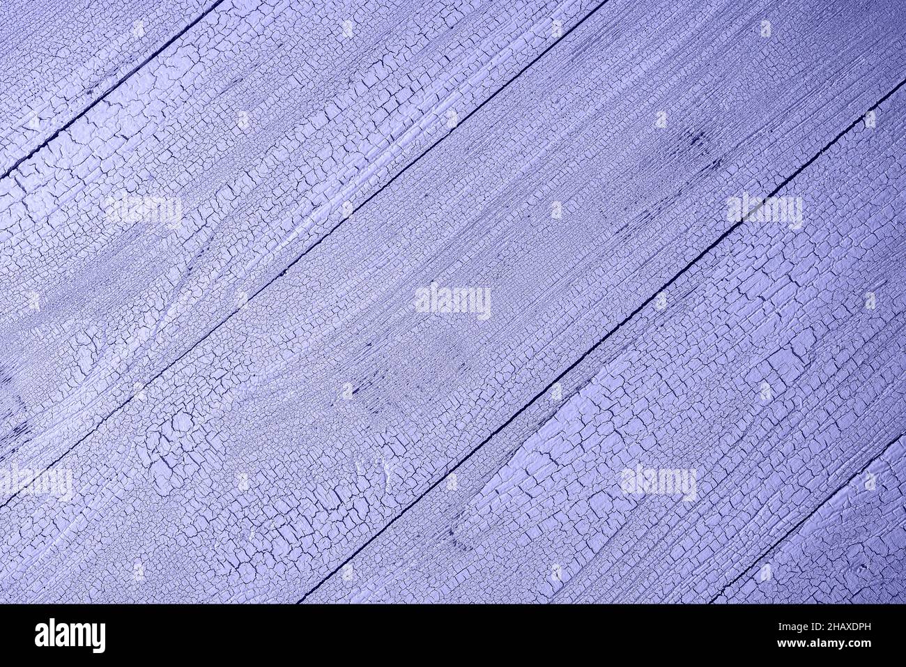 Natural textured wooden planks painted with craquelure effect and toned in very peri, color of year 2022 . Table surface with diagonal layout of plank Stock Photo