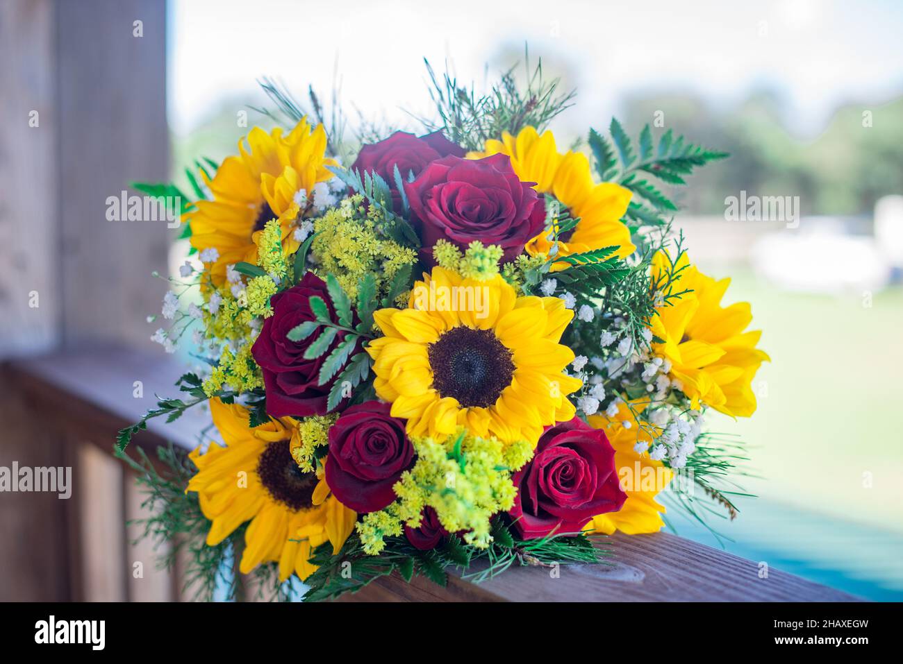 Beatifull sunflower and red roses bridal bouquets on wood porch Stock