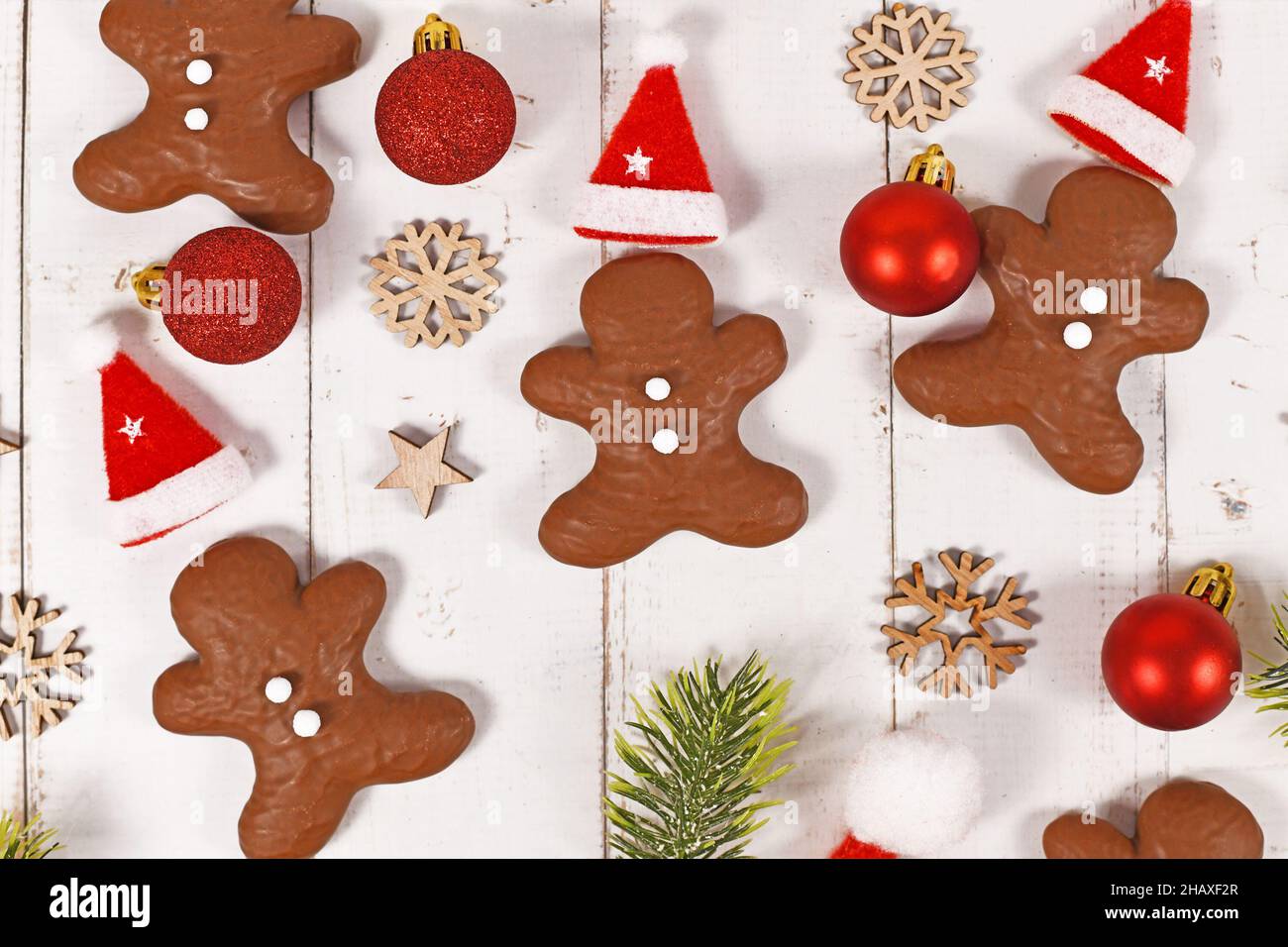 Gingerbread glazed with chocolate in shape of men between Christmas decoration Stock Photo