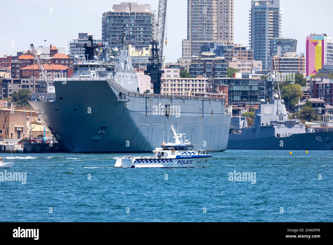 HMAS Canberra LO2 of the Royal Australian Navy at Garden Island naval base in Sydney, an amphibious assault ship launched in 2011. Police boat nearby Stock Photo