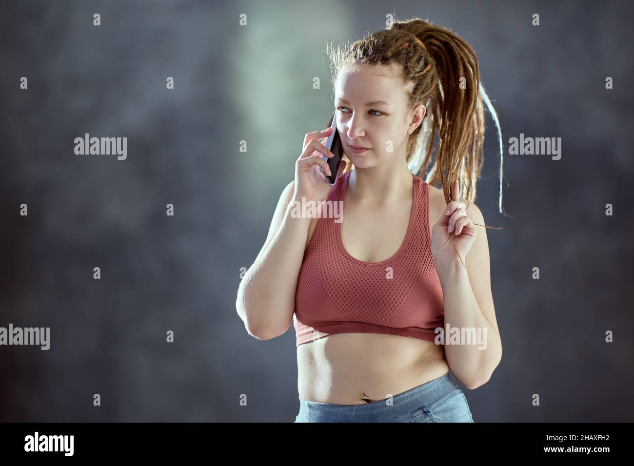 Caucasian woman with braided hair speaks on telephone. Stock Photo