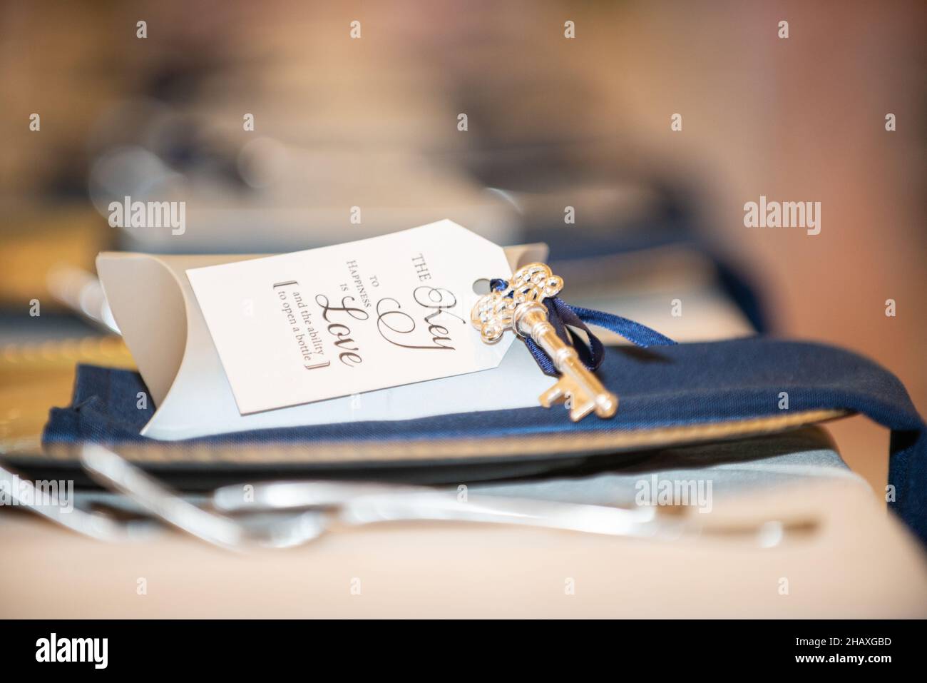 'the key to happiness is love and the ability to open a bottle ' guest gift with skeleton key and wedding reception Stock Photo
