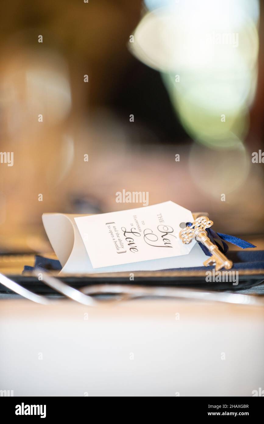 'the key to happiness is love and the ability to open a bottle ' guest gift with skeleton key and wedding reception Stock Photo