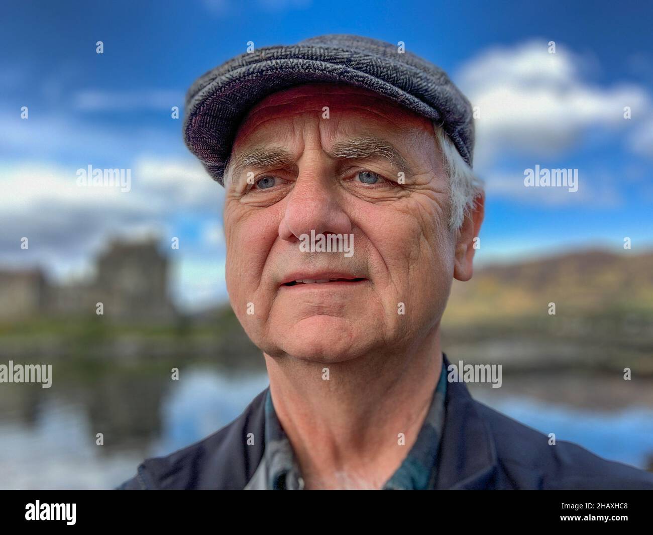Portrait of a man wearing a flat cap standing in rural landscape , Inner Hebrides, Scotland, UK Stock Photo
