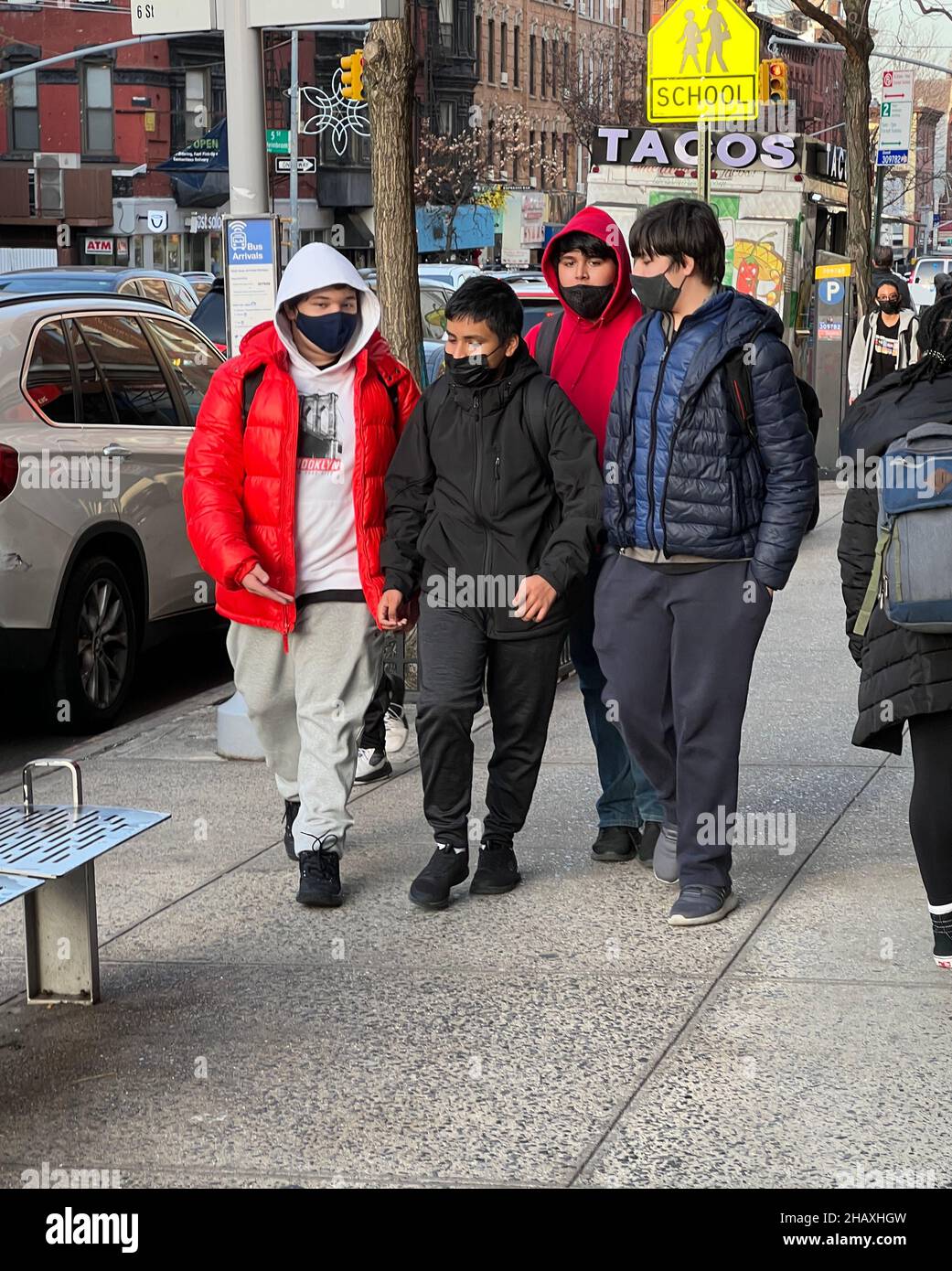 Junior High School students walk on 7th Avenue in Park Slope Brooklyn after school wearing face masks with the pandemic  continuing in November 2021. Stock Photo
