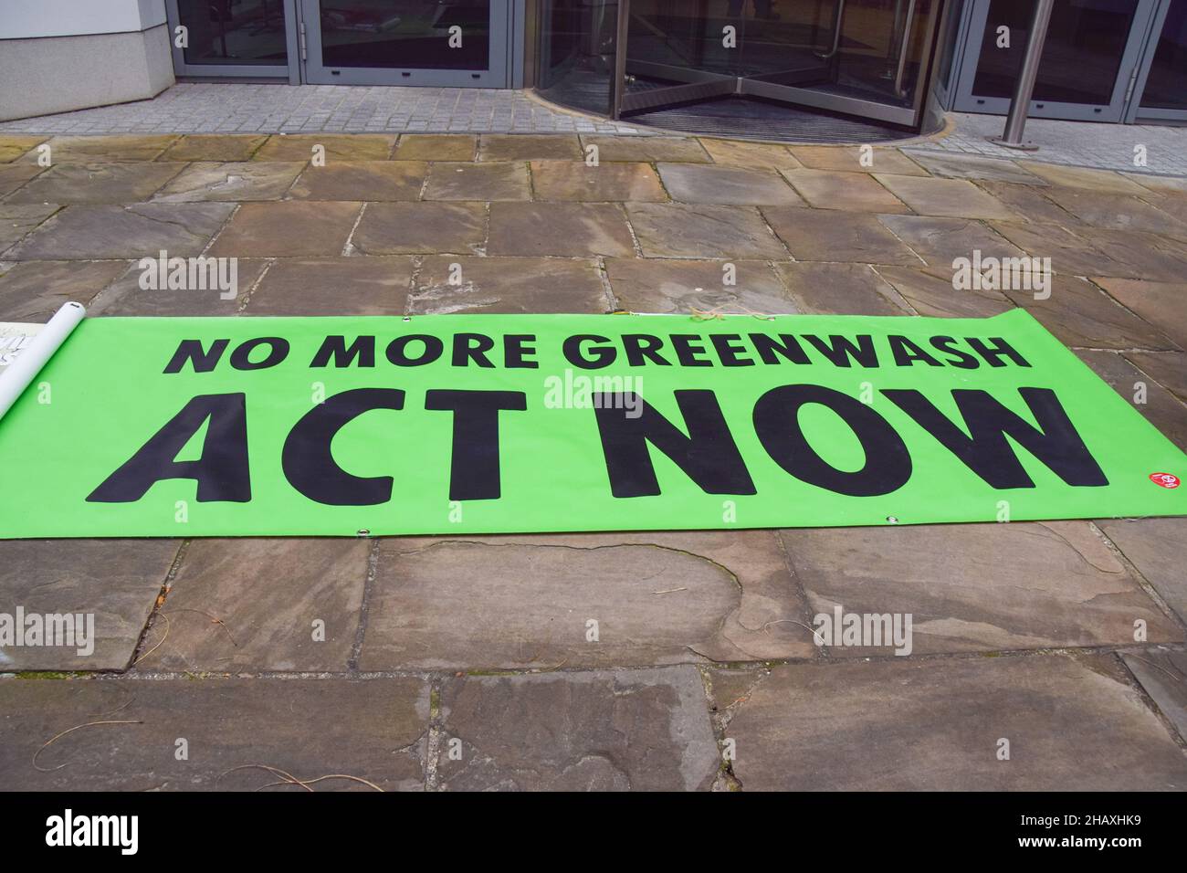 London, UK. 15th Dec, 2021. 'No More Greenwash: Act Now' banner is seen during the demonstration.Extinction Rebellion activists dumped plastic bottles and tin cans outside Coca-Cola European Partners headquarters in Uxbridge. In addition to global pollution, the activists accuse the soft drinks giant of manipulation, human rights violations and corporate greed. Credit: SOPA Images Limited/Alamy Live News Stock Photo