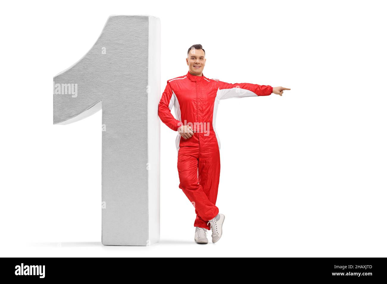 Full length portrait of a racer in a red suit leaning on number one and pointing to the side isolated on white background Stock Photo