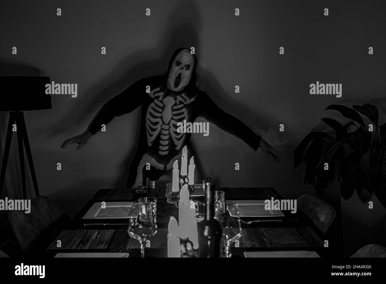 Grayscale shot of a man in a skeleton costume for Halloween Stock Photo