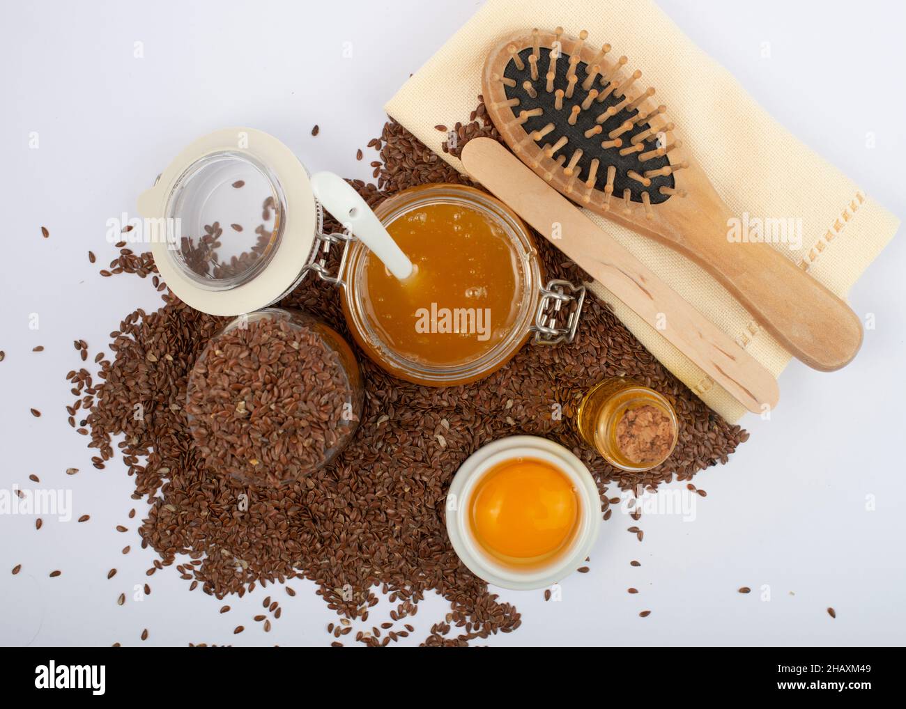 Brown flax seeds, linseeds oil, egg, honey and hair brush on white  background. Hair care mask Stock Photo - Alamy