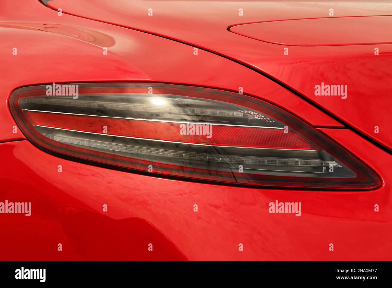 Car headlights. Luxury Headlights. Part of a red car close up. Bumper
