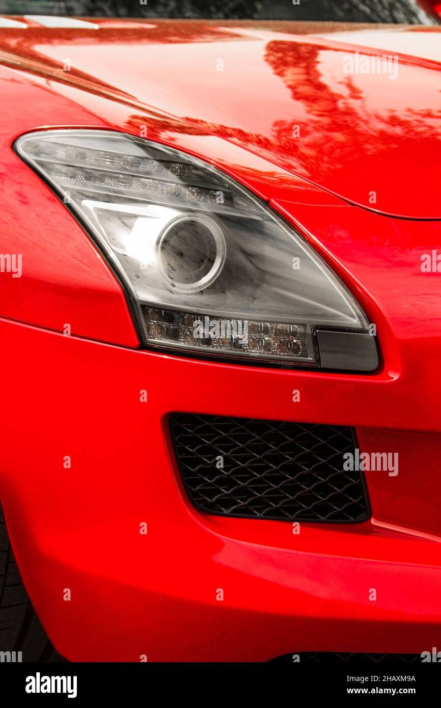 Car headlights. Luxury Headlights. Part of a red car close up. Bumper