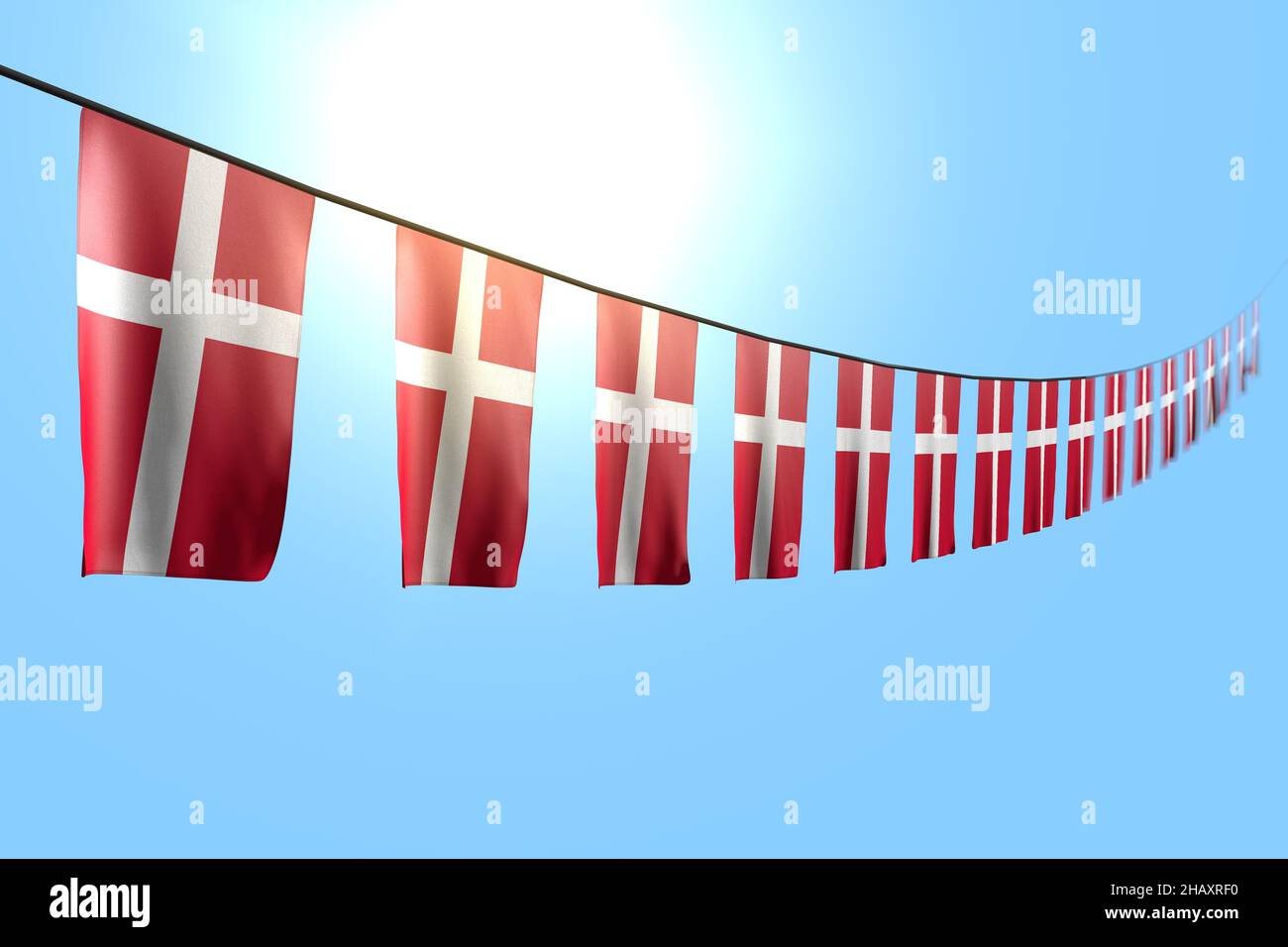 pretty many Denmark flags or banners hangs diagonal on rope on blue sky ...