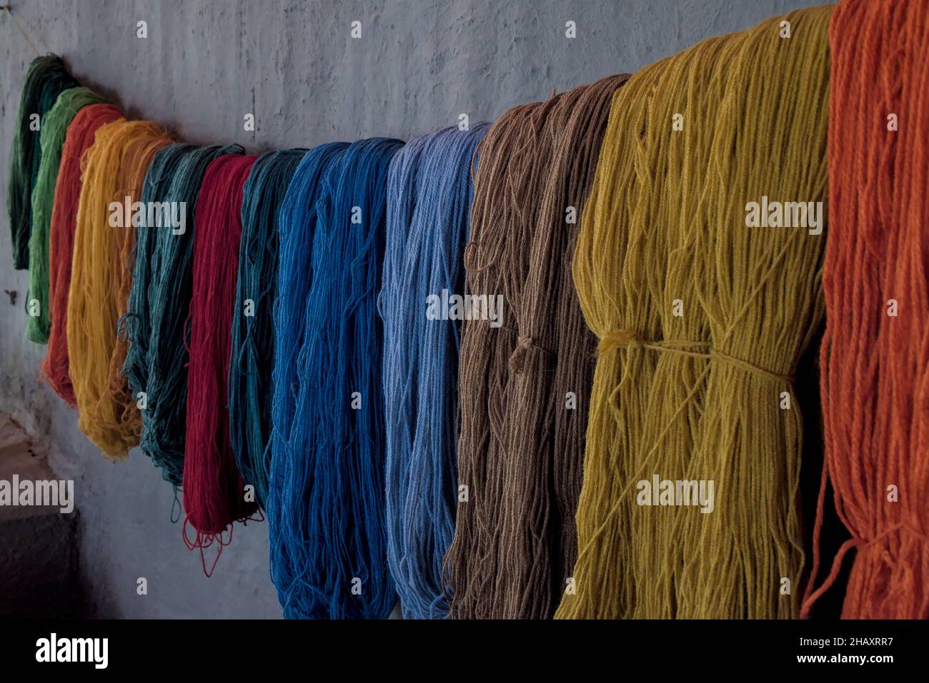 Alpaca llama wool yarn that has been dyed using traditional natural methods by andean indigenous people in peru for toursits to buy textile. Stock Photo