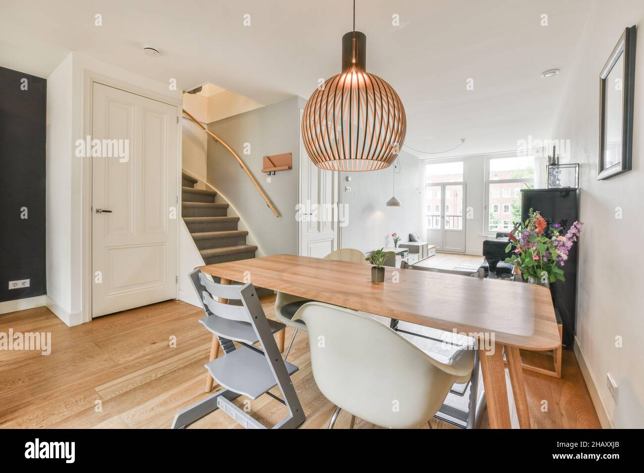 Spacious light dining zone in modern house furnished with wooden table