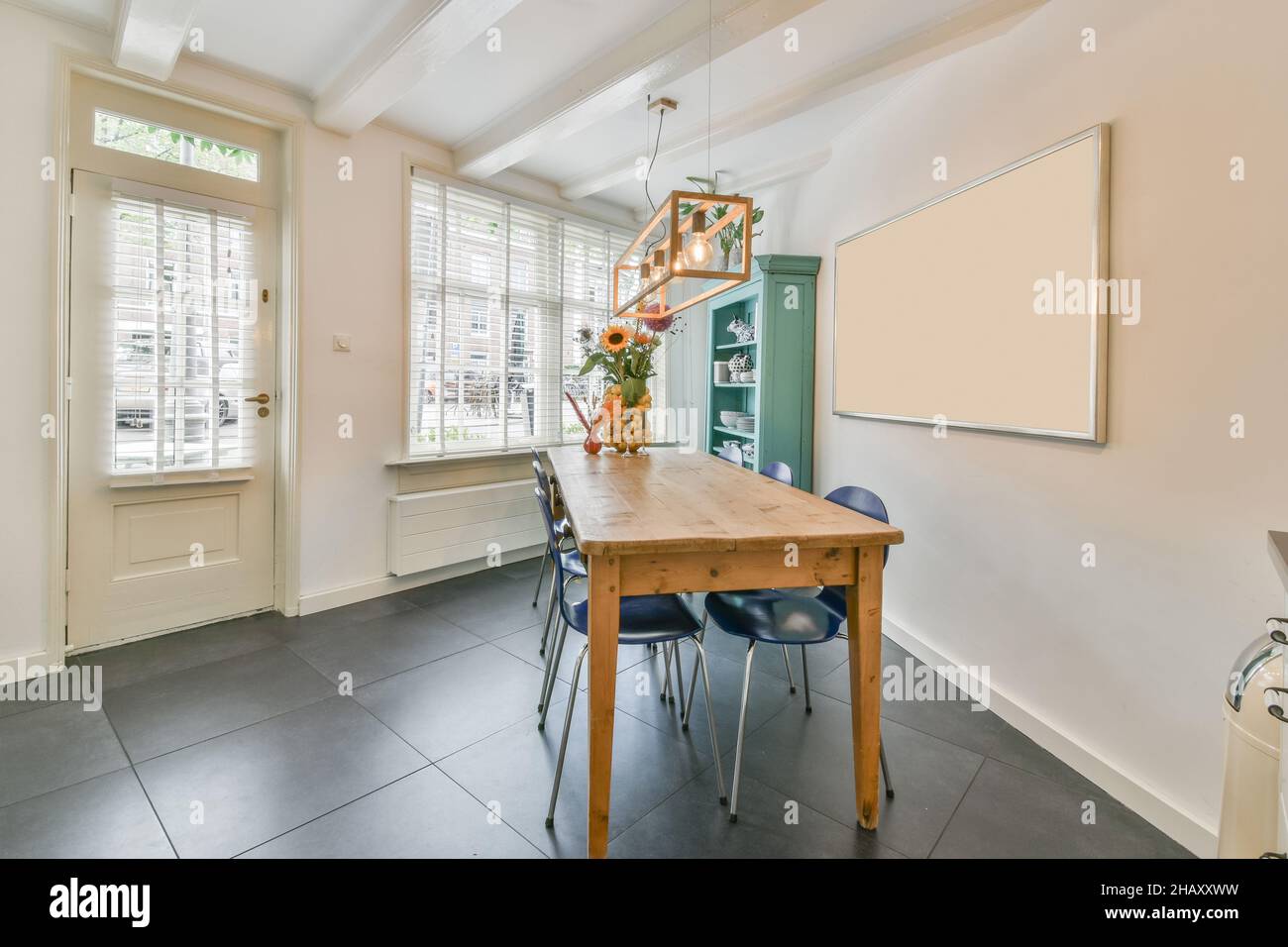 Interior of kitchen with wooden table and blue chairs and white