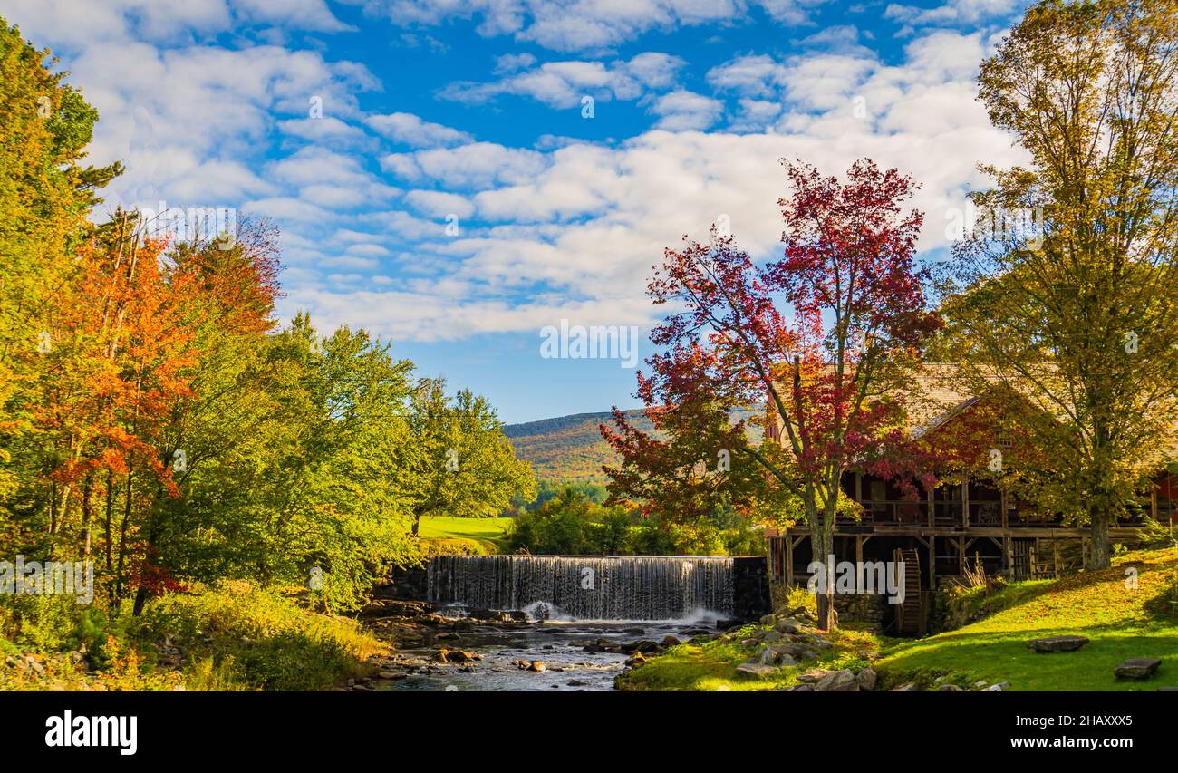 beautiful setting of the old Mill Museum, water wheel, millpond and waterfall on the West River in historic Weston Village in Vermont Stock Photo